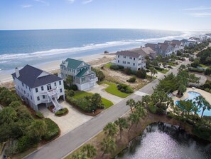 A coastal residential area with beachfront properties, a swimming pool, and a well-maintained landscape.