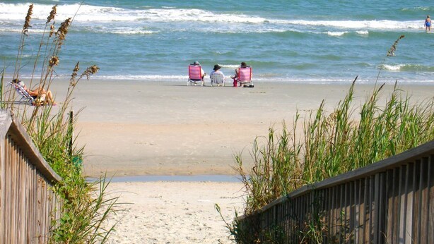 A beach with a wooden boardwalk leading to a sandy shore. - Nice Condo, Partial Ocean Views, Pool-307 Litchfield Retreat (Pawleys Island)