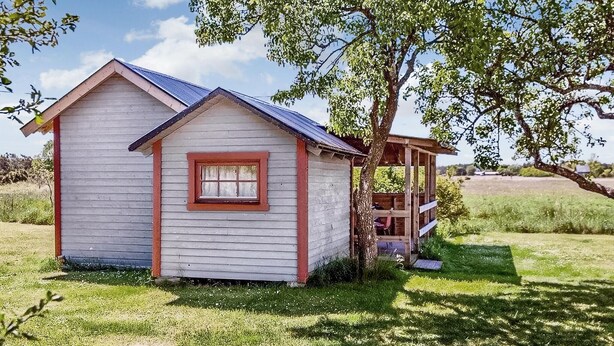 A small, single-story wooden cabin with a gabled roof and a small porch. - Lovely home in Visby with WiFi (Visby)