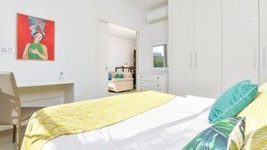 Quarto com cama, escrivaninha e guarda-roupa.
