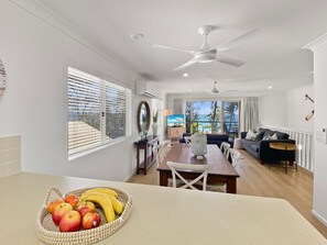 Eine moderne Küche mit Essbereich, Deckenventilator und Ausblick nach draußen.