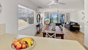 Una cocina moderna con comedor, ventilador de techo y vistas al exterior.