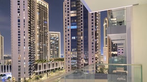 Un immeuble moderne de grande hauteur, doté d’un balcon en verre qui reflète l’architecture environnante.