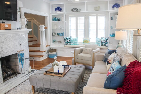 A living room with a fireplace, a sofa, a coffee table, and a bookshelf.