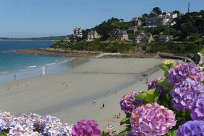 A beach with people, a bridge, and buildings on a hillside. - Stone House Pleumeur-Bodou near Pink Beaches (Pleumeur-Bodou)