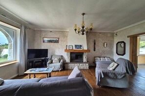 Ein Wohnzimmer mit Kamin, Fernseher und Sitzecke.