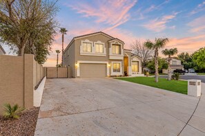 A two-story house with a garage, a driveway, and a well-maintained lawn. - The Cardinal | Ultimate Group Retreat in Glendale (Glendale)