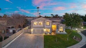 A two-story house with a garage, a driveway, and a well-maintained lawn. - The Cardinal | Ultimate Group Retreat in Glendale (Glendale)