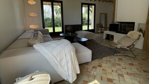 A spacious bedroom with a large bed, a seating area, a TV, and a fireplace. - Renovated country property with fireplace, near forest (Le Mont-Saint-Adrien)