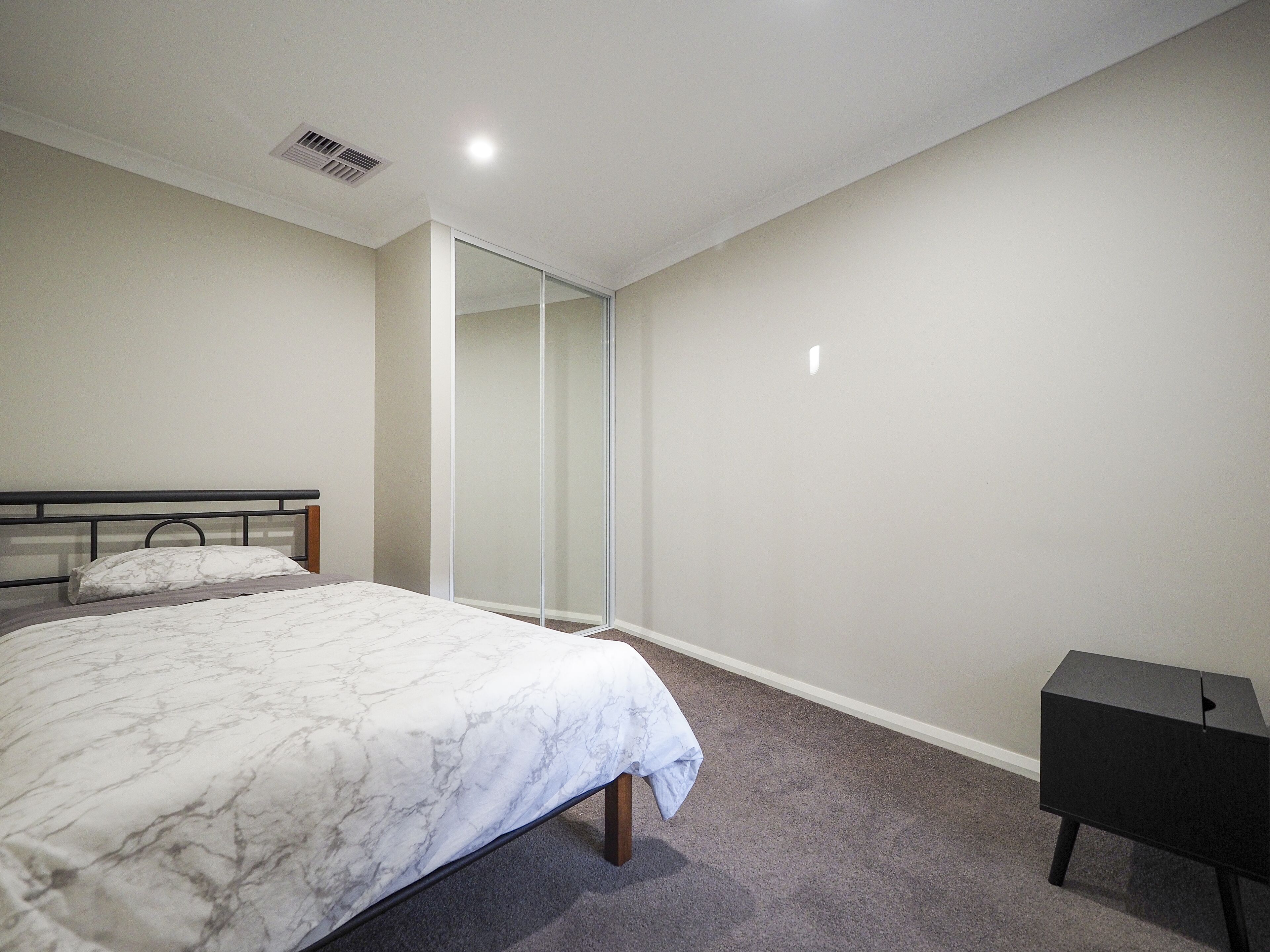 Ein Schlafzimmer mit Bett, Kleiderschrank und Schreibtisch.