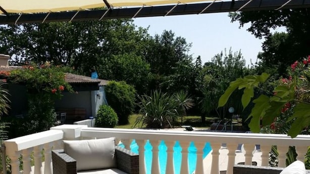 An outdoor patio with a covered seating area, including a sofa and two armchairs, surrounded by a white balustrade. - CHARMING HOUSE WITH PRIVATE POOL (Prunelli-di-Fiumorbo)