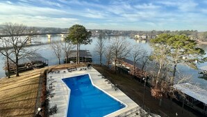 Una piscina con vista a un lago y un puente al fondo.