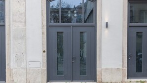A building facade with two symmetrical grey doors, each marked with a number (294 and 292).