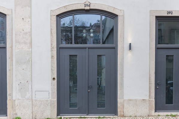 A building facade with two symmetrical grey doors, each marked with a number (294 and 292).