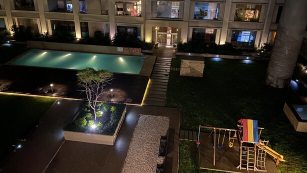 Un hotel con varias plantas, piscina y área de juegos para niños.