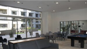 Un espacio lounge moderno con mesa de billar, sofás y equipo de juegos.