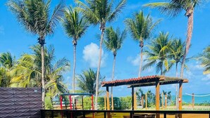 Una piscina con vista despejada al océano, rodeada de palmeras y una terraza de madera.