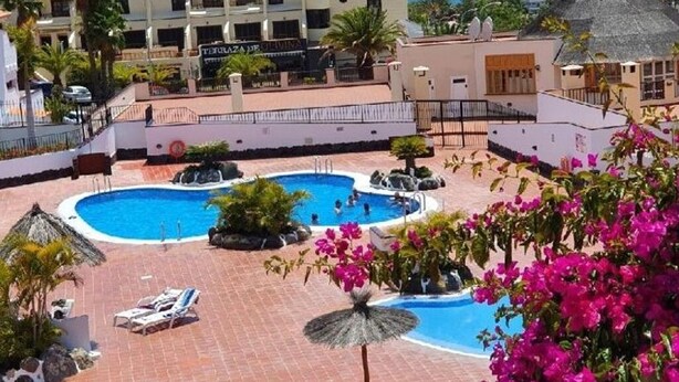 A resort with a pool area, palm trees, and a view of the sea. - El Mirador Los Cristianos, 20 sqm terrace and incredible 40 sqm roof terrace (CN)