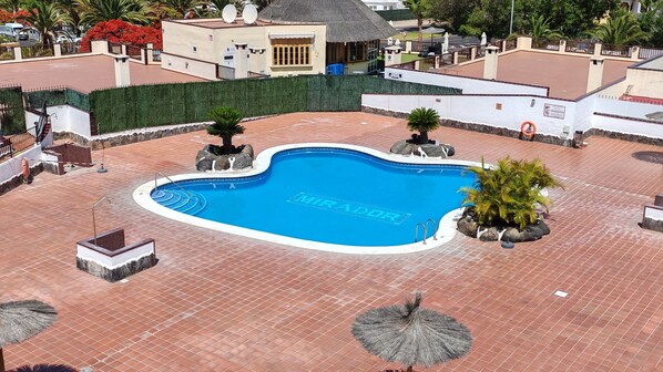 A swimming pool with a tiled deck, surrounded by a low wall and potted plants. - El Mirador Los Cristianos, 20 sqm terrace and incredible 40 sqm roof terrace (CN)
