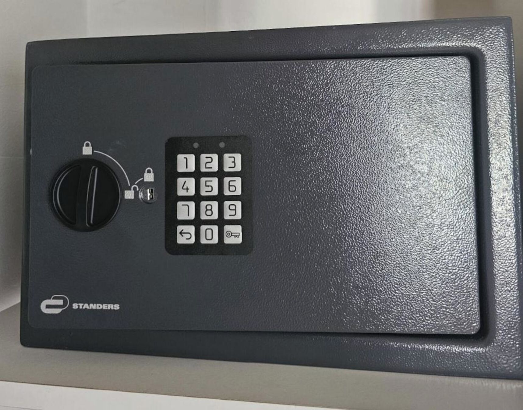 Un coffre-fort noir doté d’un cadran à combinaison et d’un clavier.
