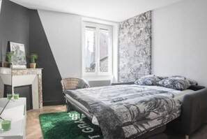 Une chambre à coucher moderne avec un lit, un bureau et une fenêtre.