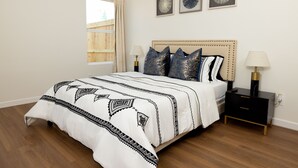 A bedroom with a bed, bedside tables, and a window.