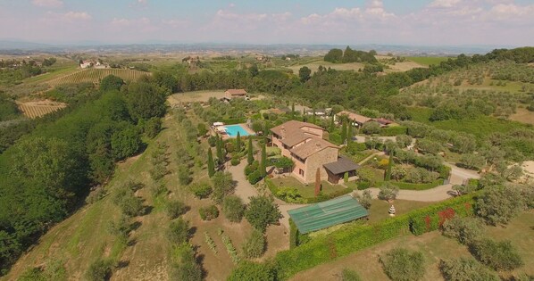 Una extensa propiedad con piscina, cancha de tenis y viñedo.