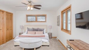 A bedroom with a bed, a ceiling fan, a TV, a window, and a wardrobe. - Amazing Family Retreat w/ Fenced Yard & BBQ! (Stevens Point)