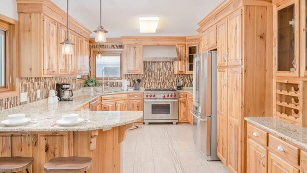 A kitchen with wooden cabinets, granite countertops, stainless steel appliances, and pendant lighting. - Amazing Family Retreat w/ Fenced Yard & BBQ! (Stevens Point)