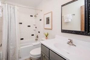 A bathroom with a bathtub, toilet, sink, and a large mirror. - Amazing Family Retreat w/ Fenced Yard & BBQ! (Stevens Point)