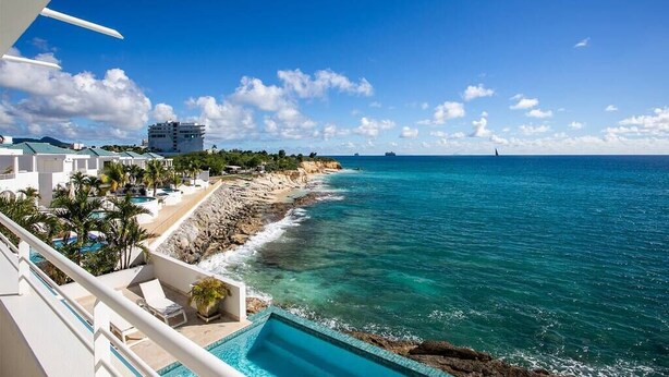 Un resort con piscina, playa y vista al océano.