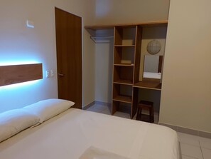Une chambre à coucher avec un lit, une armoire et un petit tabouret.