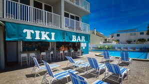 A TIKI BAR with outdoor seating and a pool area. - Beautiful Beach View Condo with heated pool. No Resort Fees. (Treasure Island)