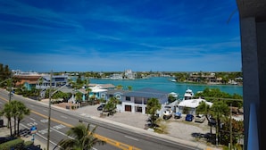 A coastal view with a marina, houses, and a clear blue sky. - Beautiful Beach View Condo with heated pool. No Resort Fees. (Treasure Island)