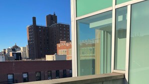 A balcony with a view of city buildings. - Stylish studio apartment in the heart of East Harlem (New York)