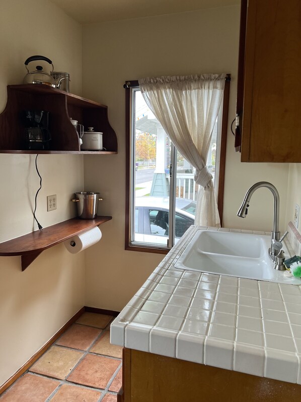 Enjoy cooking in this kitchen with a stainless steel sink, coffee maker, and kettle.
