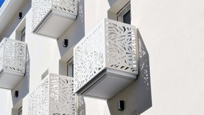 A building with multiple balconies featuring intricate white lattice designs.