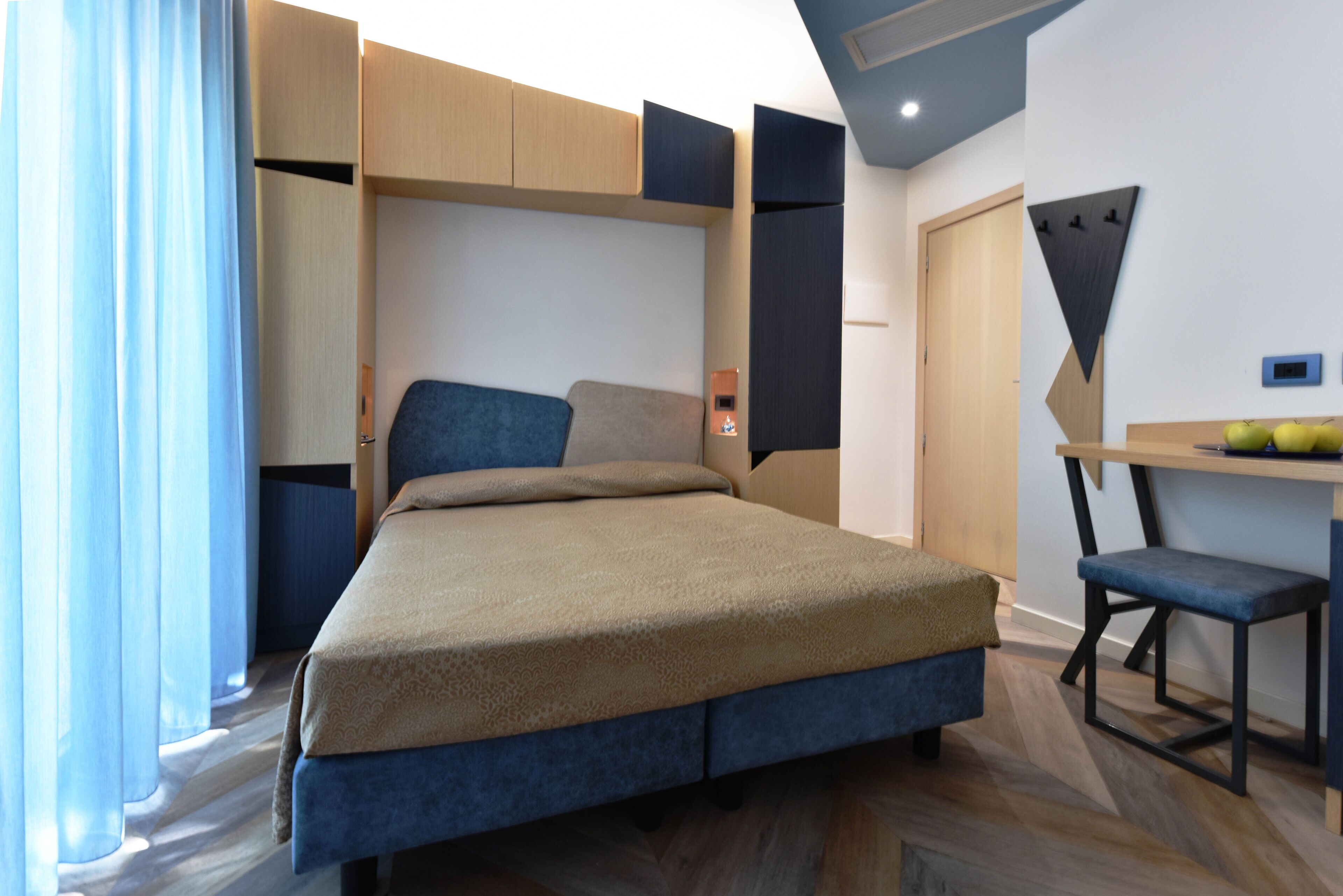 Une chambre à coucher moderne avec un lit, un bureau et une chaise.
