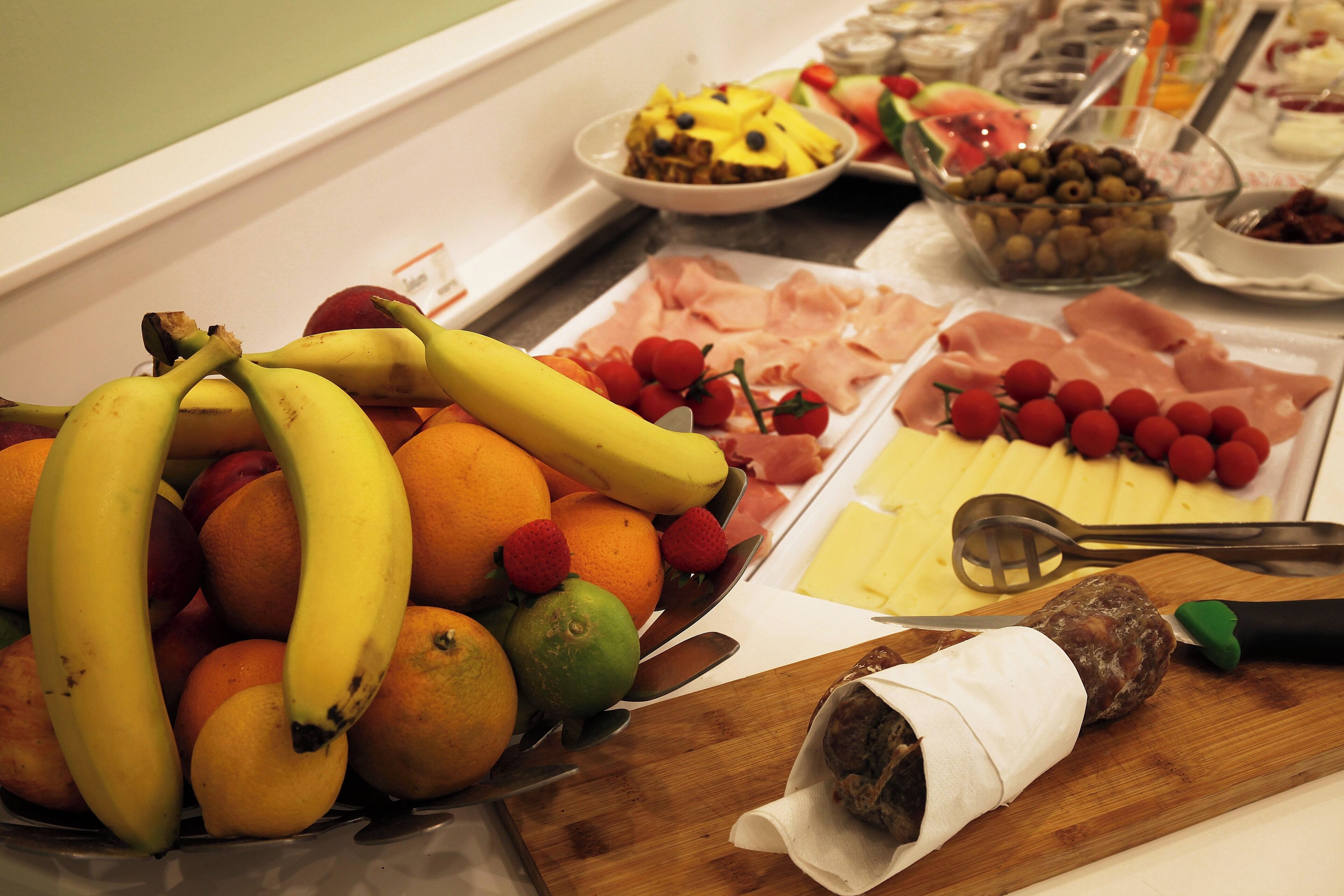 A buffet with fruits, cheeses, and meats.