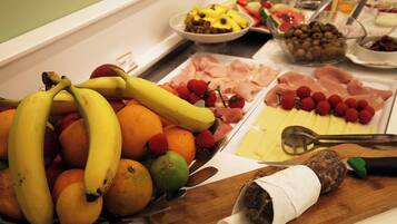 A buffet with fruits, cheeses, and meats.