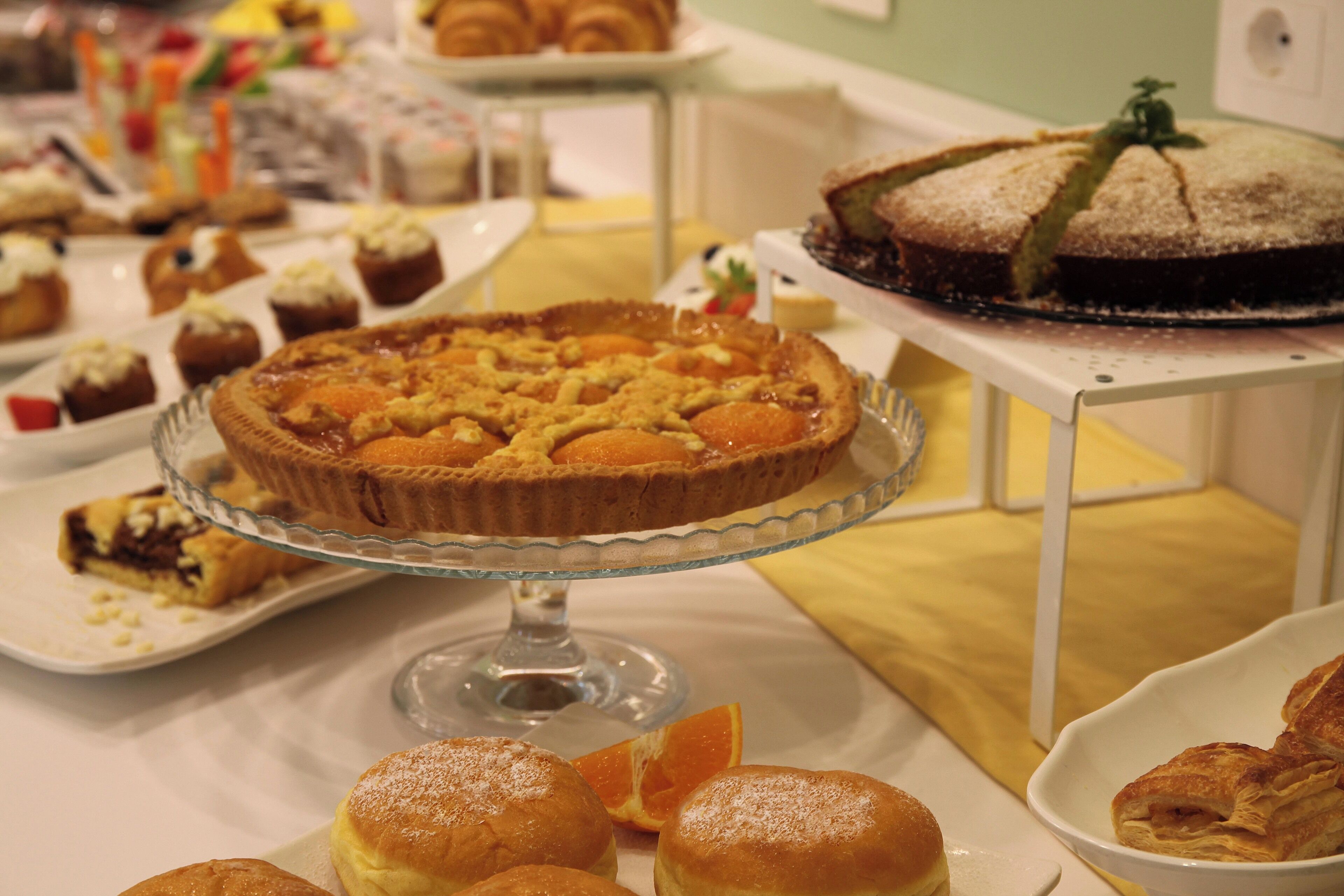 A buffet table with various desserts including pies, tarts, and pastries.