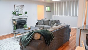 A living room with a fireplace, a sofa, a coffee table, and a window. - Spacious & Quiet Home Near DeKoevend Park (Centennial)