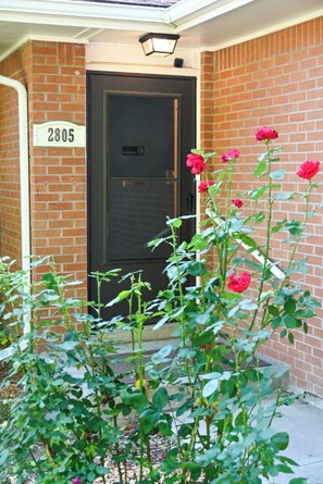 A brick building with a black door and a white sign displaying the number 2805.
