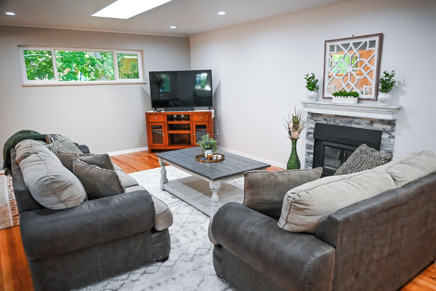 A living room with a fireplace, a television, and a sofa set.
