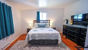 A bedroom with a bed, bedside tables, a dresser, a TV, and a window with curtains. - Spacious & Quiet Home Near DeKoevend Park (Centennial)