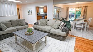 A living room with a sofa set, a coffee table, and a dining area with chairs and a table. - Spacious & Quiet Home Near DeKoevend Park (Centennial)