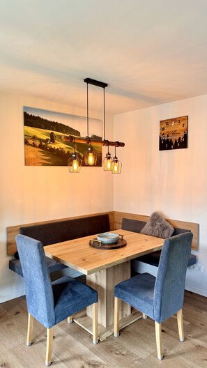Enjoy meals in this dining area with a wooden table and comfortable seating for four.