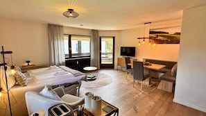 Relax in a spacious room with a large bed, flat-screen TV, and dining area.