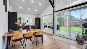 A modern kitchen with a large dining table, chairs, and a view of the outdoors. - Gorgeous home in Thyholm with WiFi (Thyholm)
