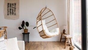 A cozy room with a hanging chair, a small table, a potted plant, and a window with curtains. - 2 bedroom nice home in Den Oever (Den Oever)